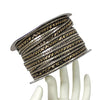 Spool of metallic ribbon on a mannequin hand against a white background