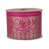 Spool of pink and gold floral ribbon on a white background