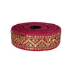 Roll of red ribbon with gold sequin pattern on a white background