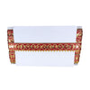 White napkin with red and gold decorative border on a white background
