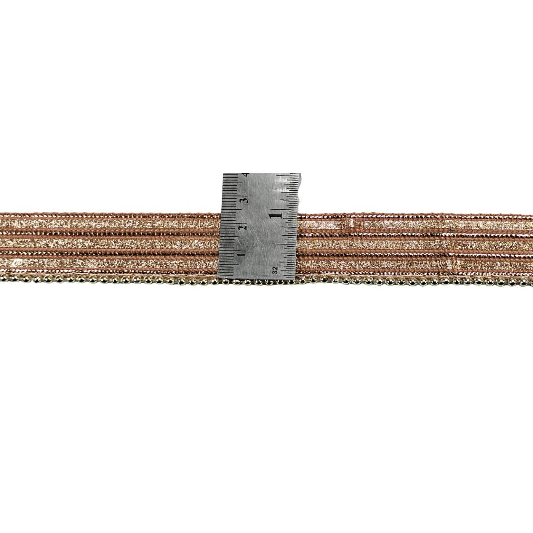 Two spools of brown thread with a metal ruler on a white background