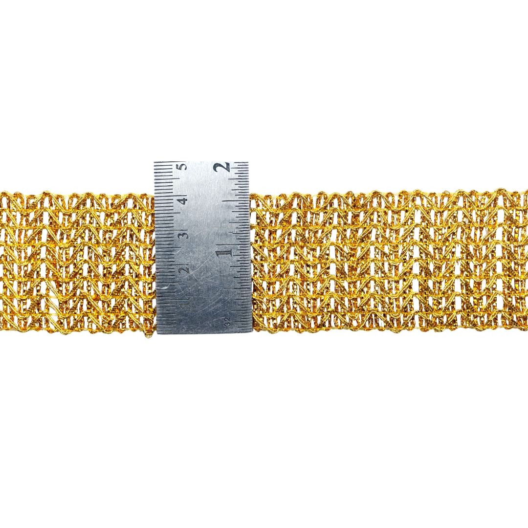 Gold chain belt with a ruler for scale on a white background