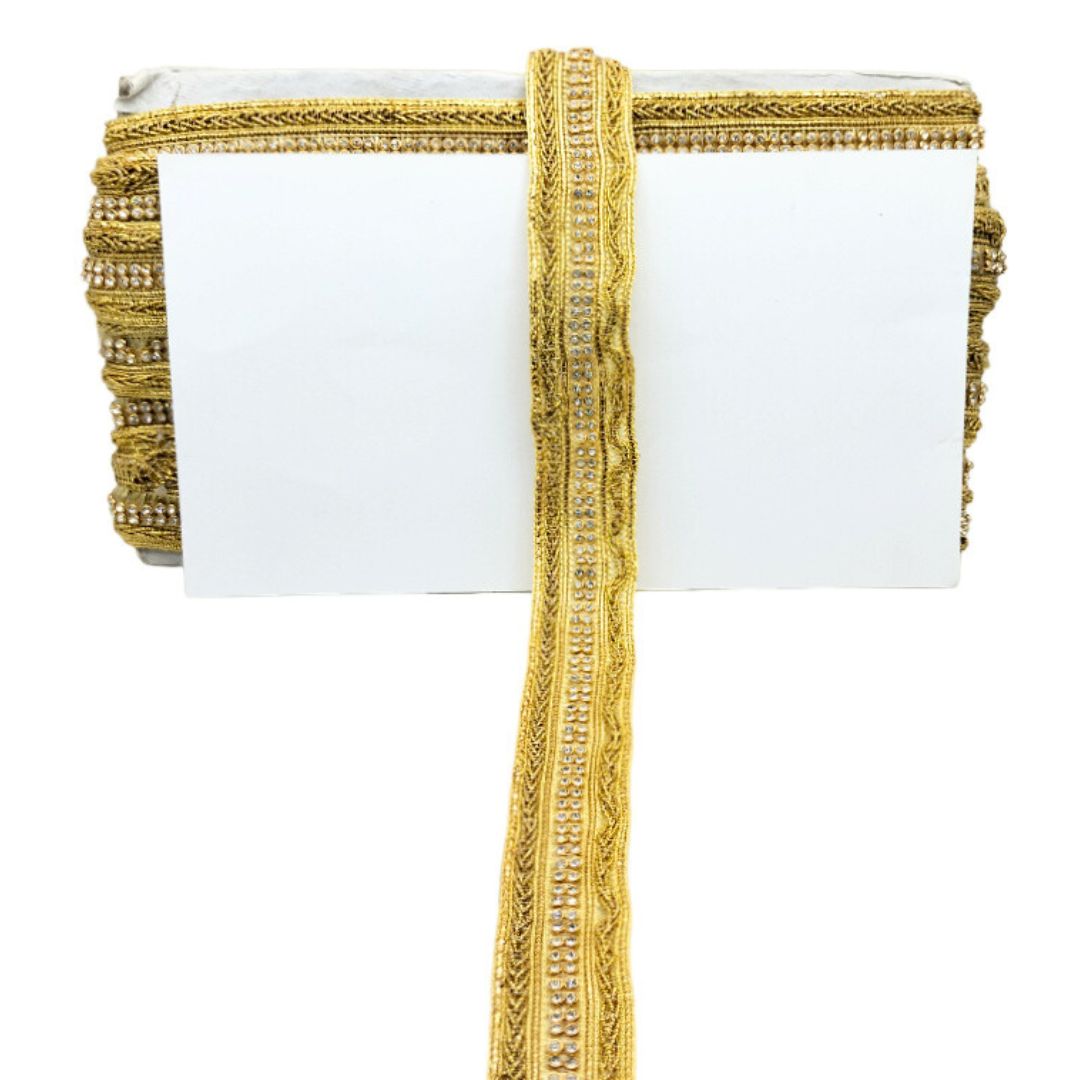 White clutch with gold decorative strap on a white background