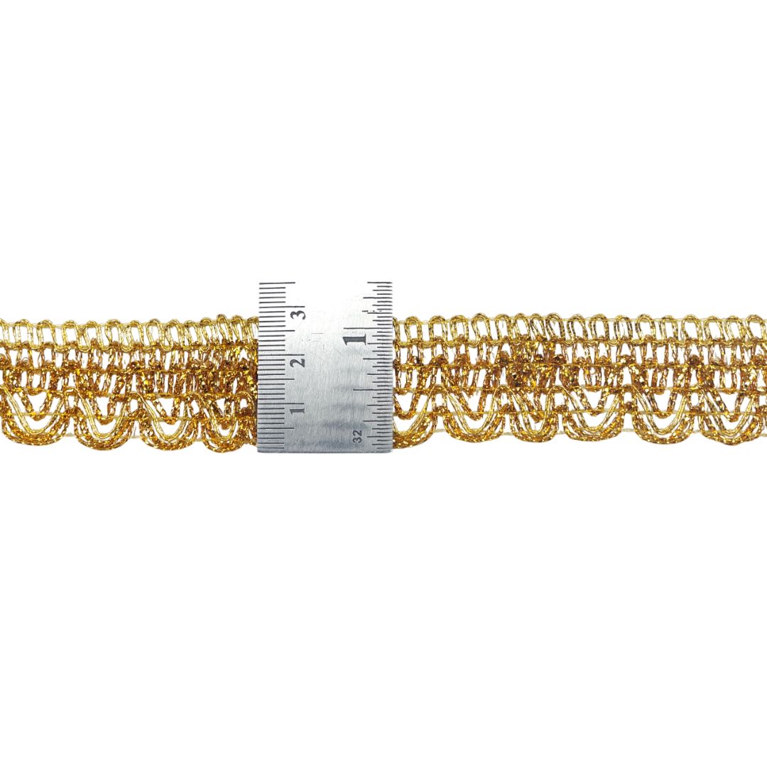 Gold lace trim with a ruler for scale on a white background
