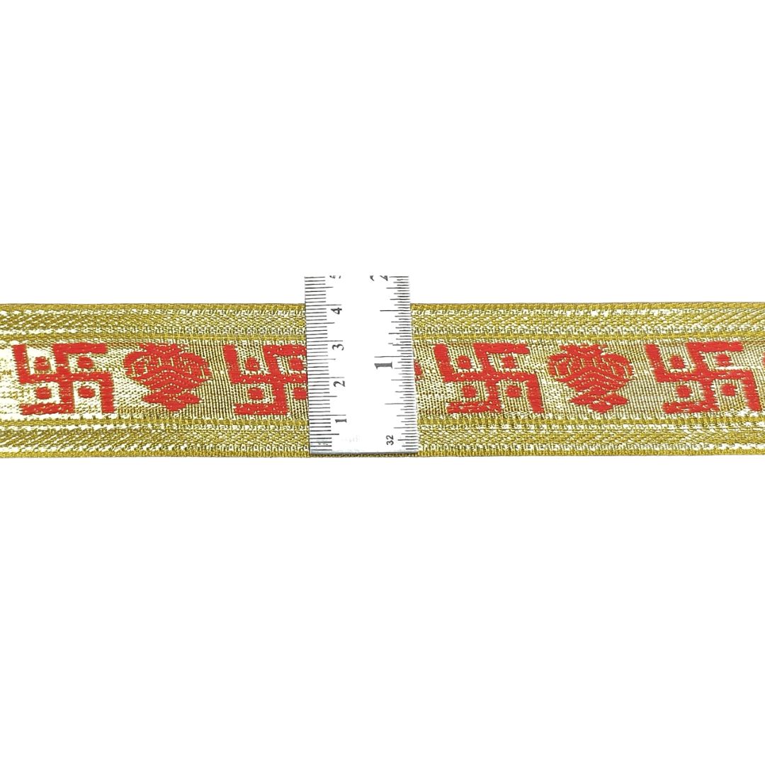 Gold ribbon with red floral pattern and a ruler for scale on a white background