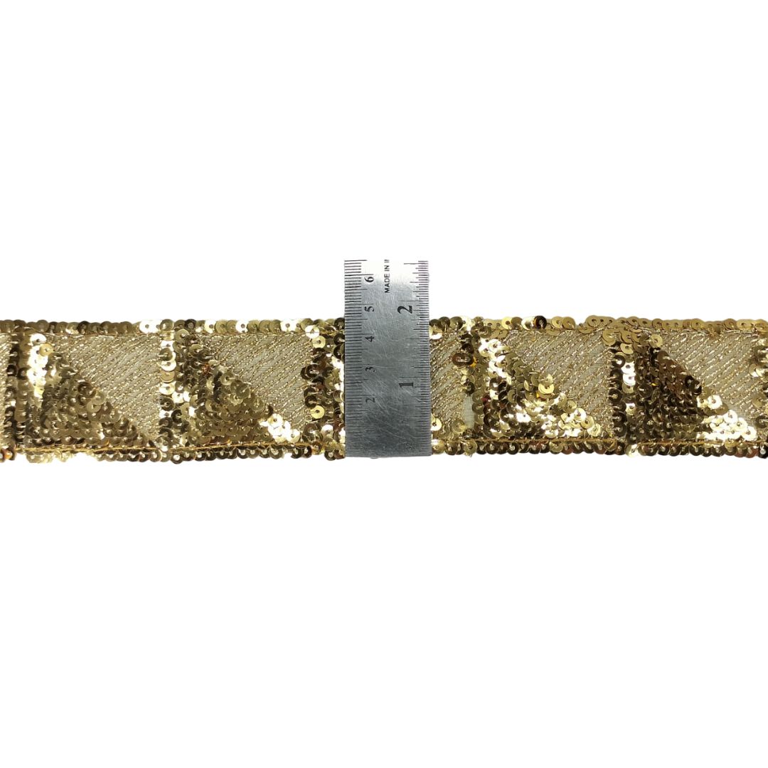 Gold sequin ribbon with a ruler for measurement on a white background