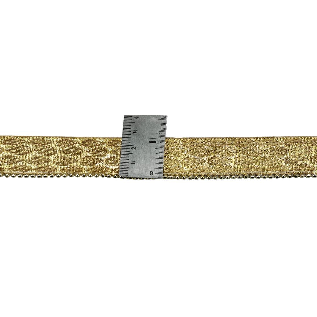 Gold woven ribbon with a ruler for scale on a white background