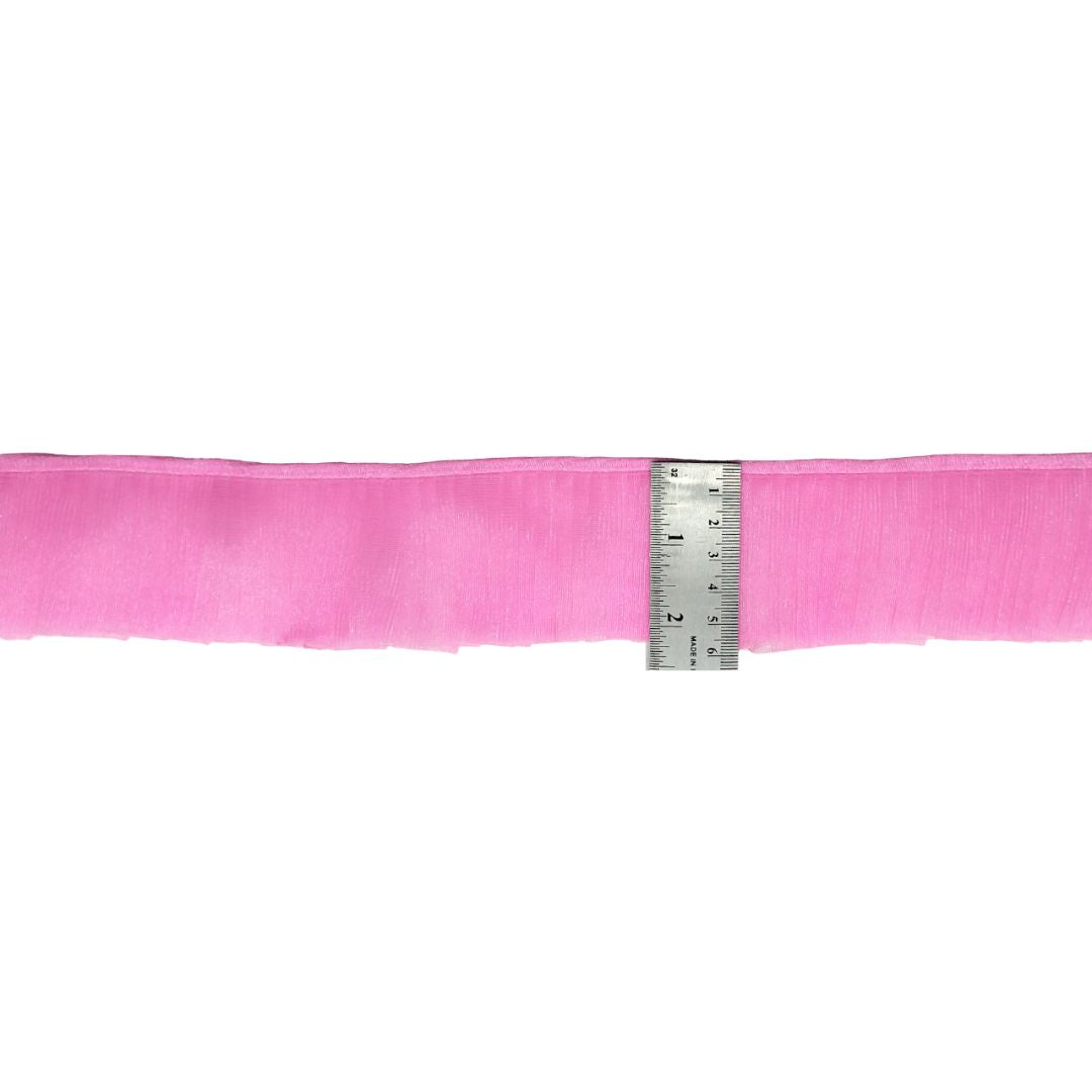 Pink ribbon with a ruler for measurement on a white background