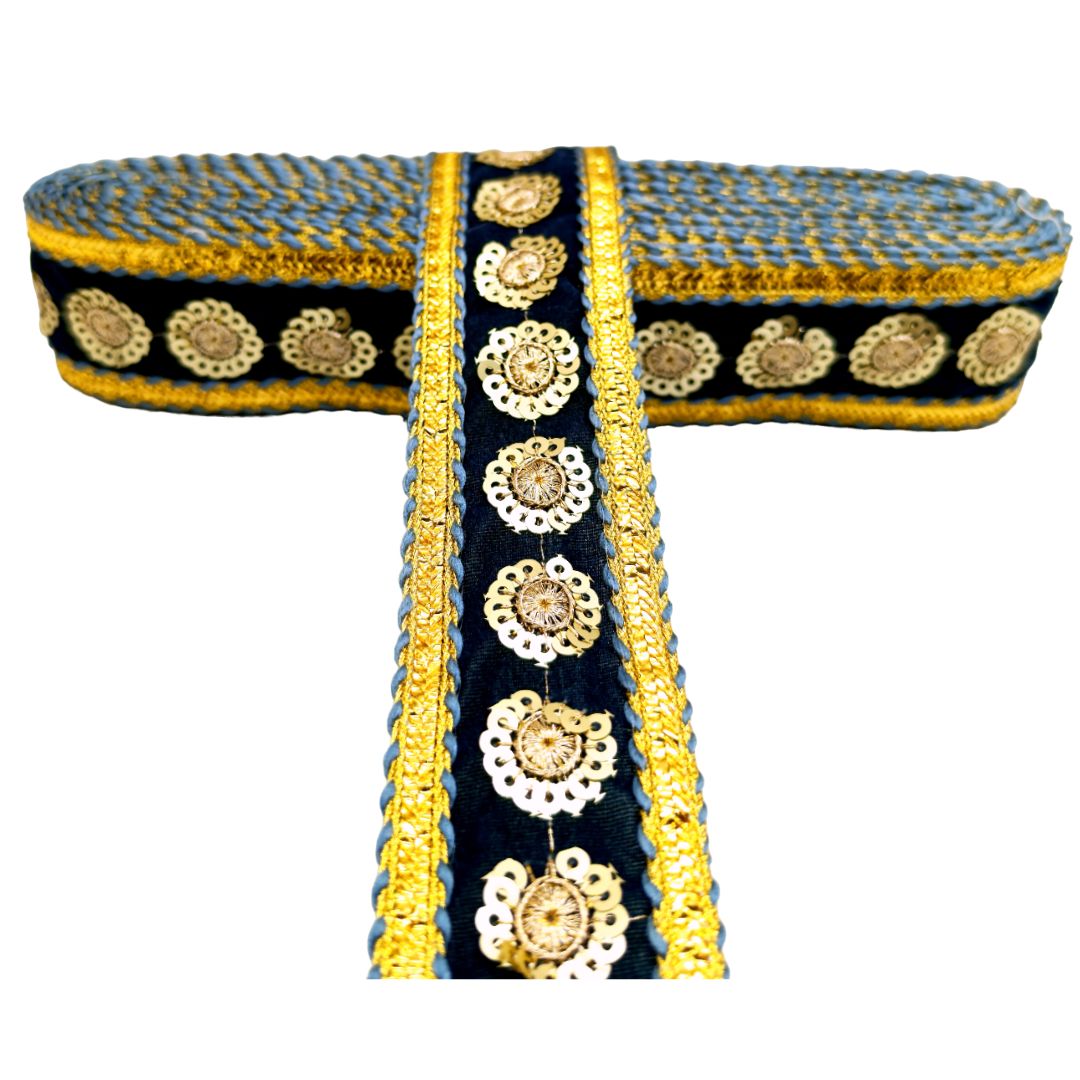 Decorative fabric strip with gold and white patterns on a blue background