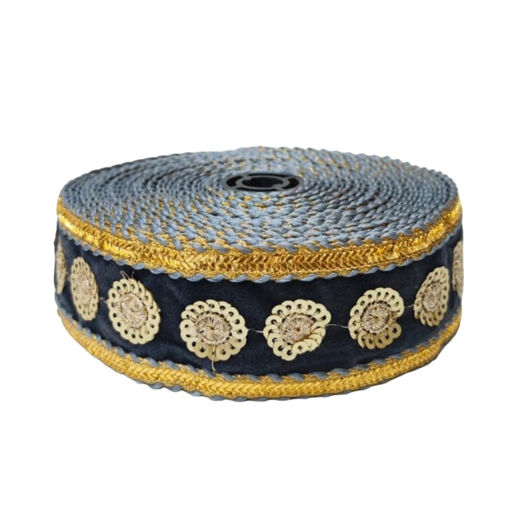 Roll of decorative ribbon with gold and blue pattern on a white background