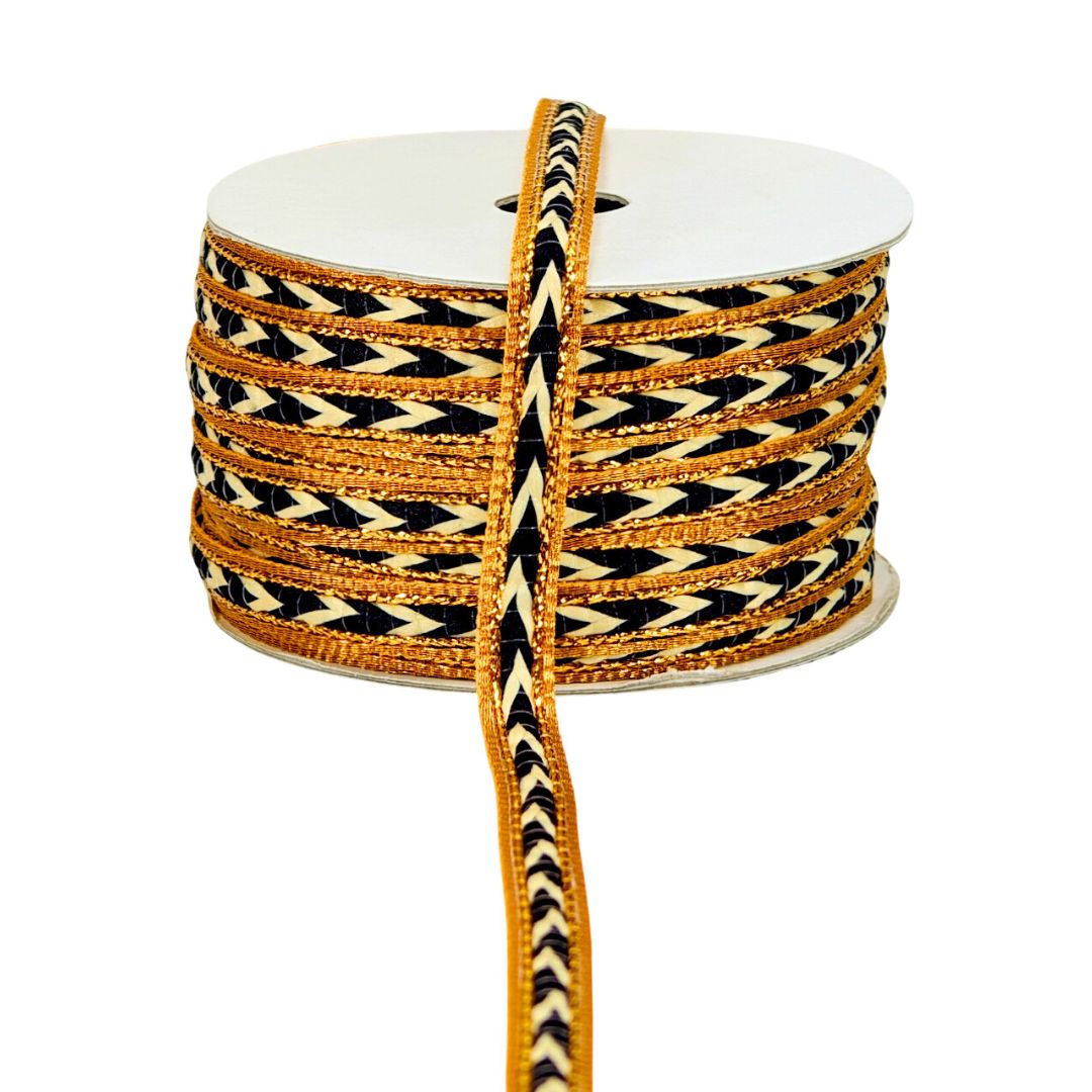 Spool of ribbon with black and gold pattern on a white background