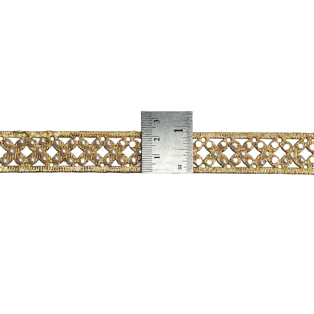 Gold lace trim with a ruler for measurement on a white background