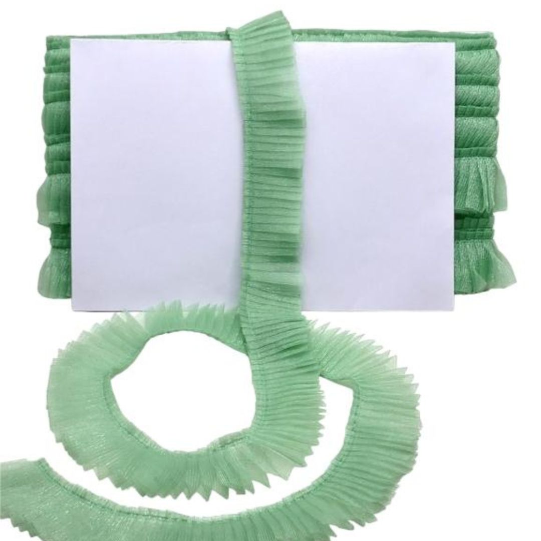 Green pleated scarf with a white card on a white background