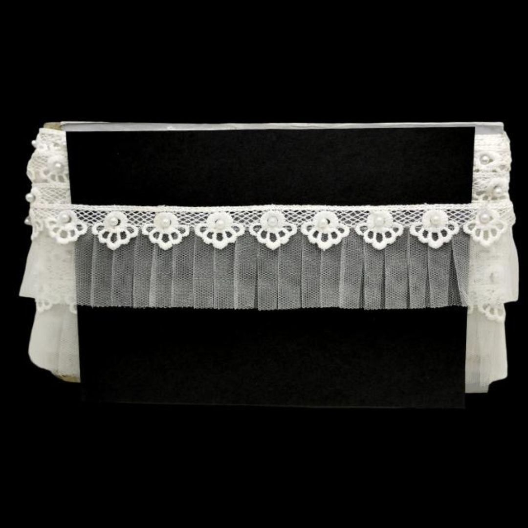 Black piano with a white lace cover on a black background