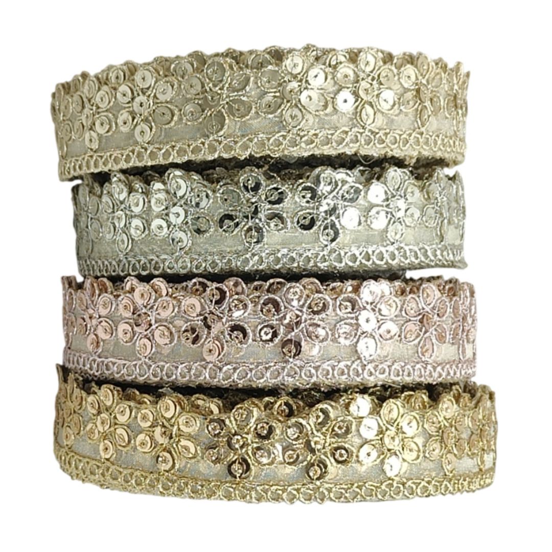 Set of four gold and silver bangles stacked on a white background
