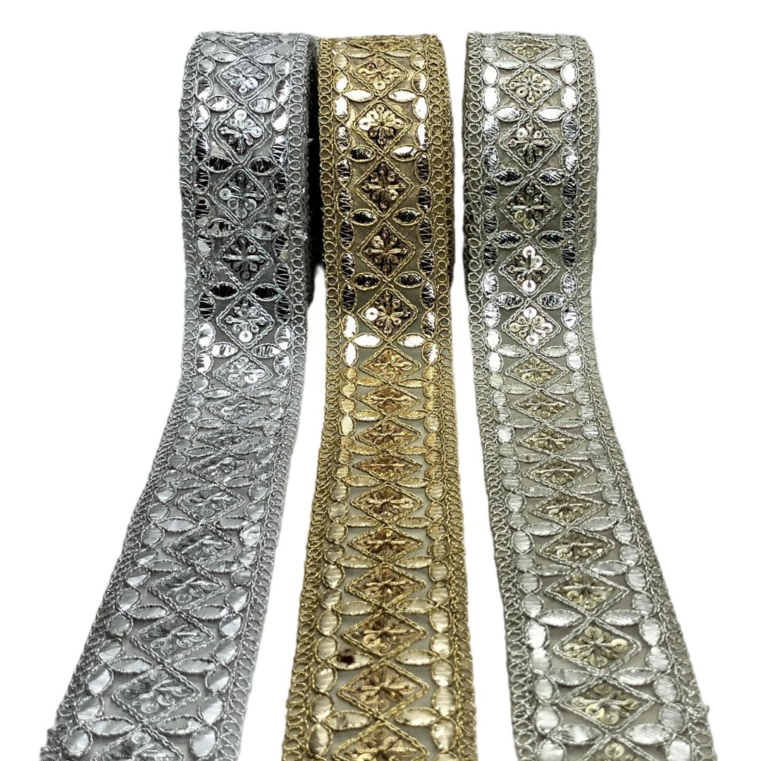 Three ribbons with intricate patterns in silver, gold, and a mix of both on a white background.