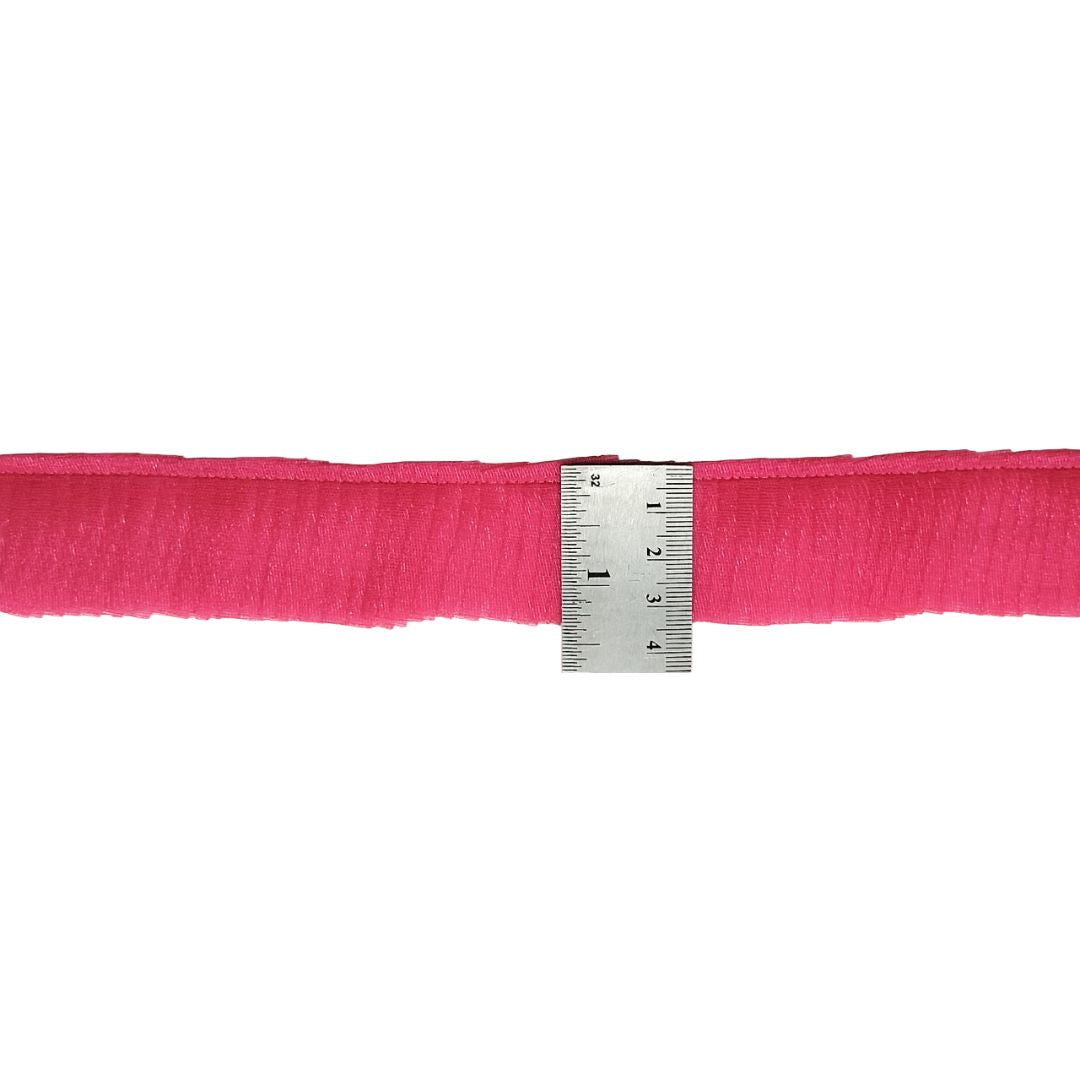 Pink ribbon with a ruler for measurement on a white background