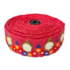 Roll of red fabric with colorful patterns on a white background