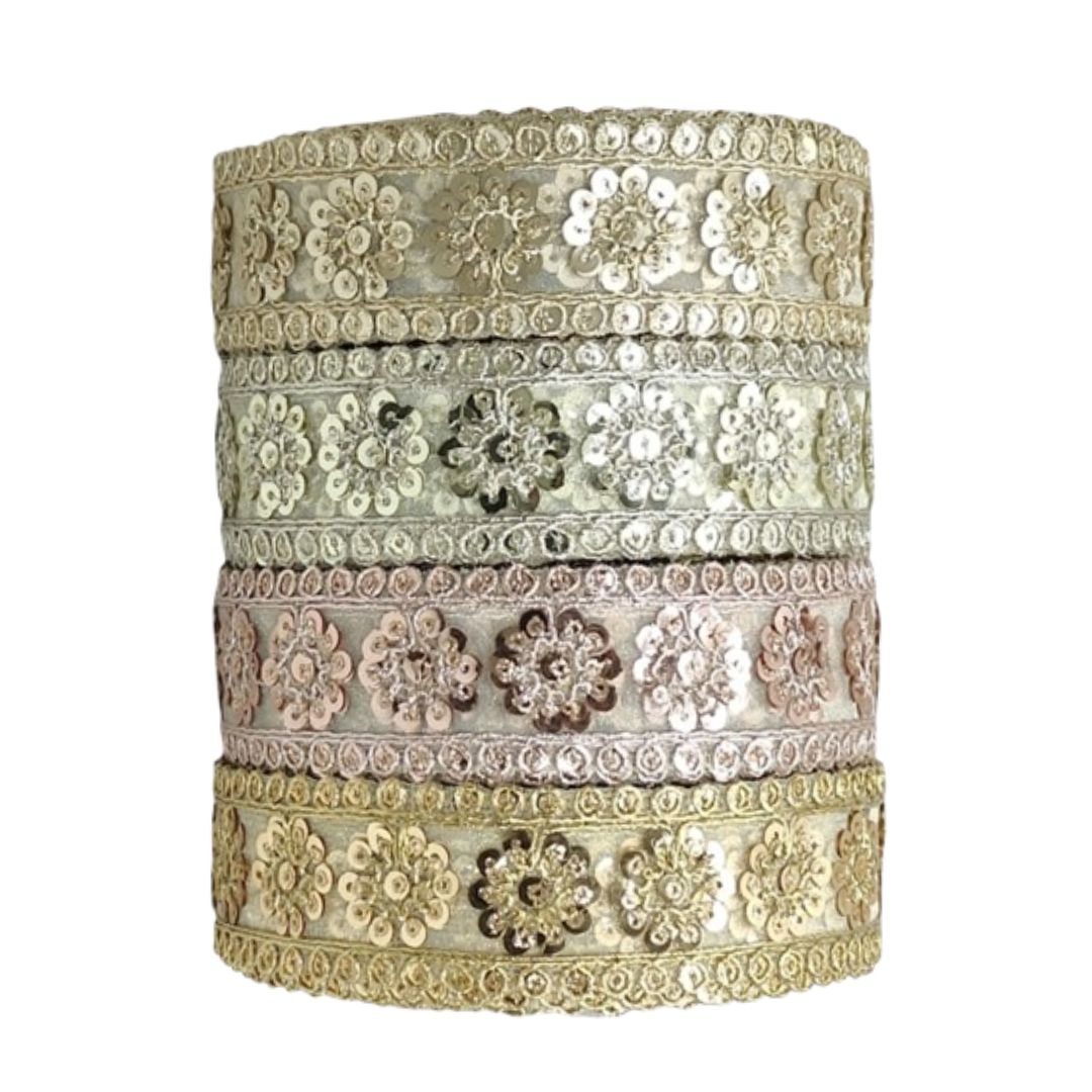 Decorative cylindrical box with floral patterns and sequins on a white background