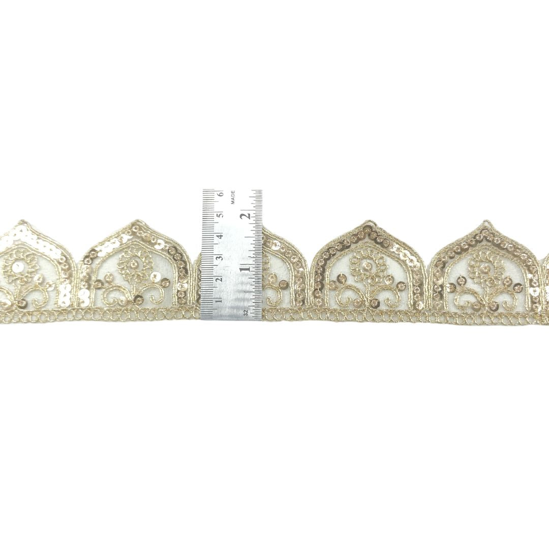 Decorative lace trim with a ruler for scale on a white background