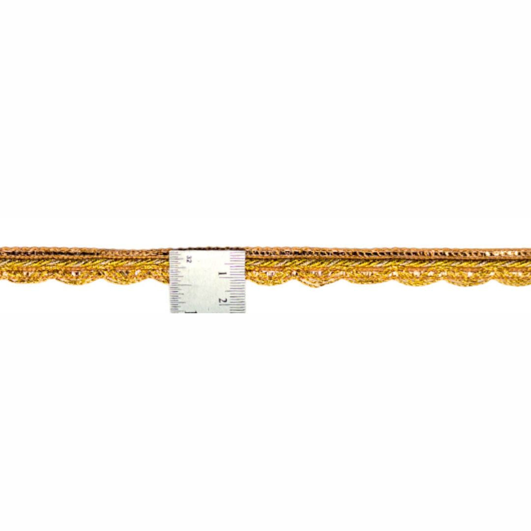 Gold lace trim with a ruler for scale on a white background