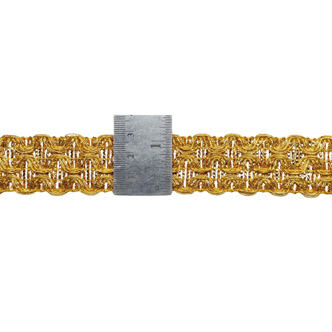 Gold lace trim with a ruler for measurement on a white background