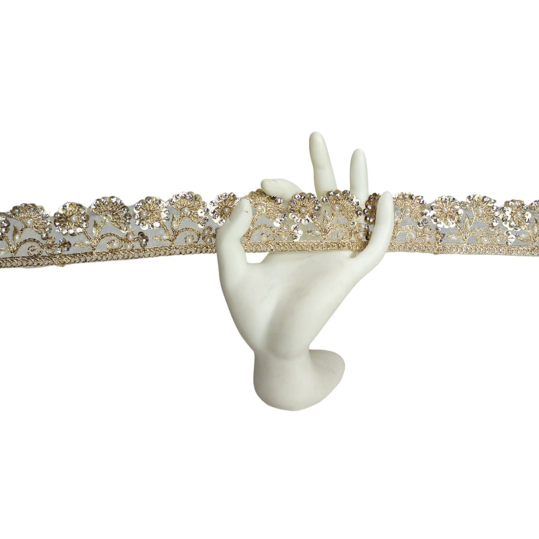 Decorative lace trim with gold and white floral patterns on a white background