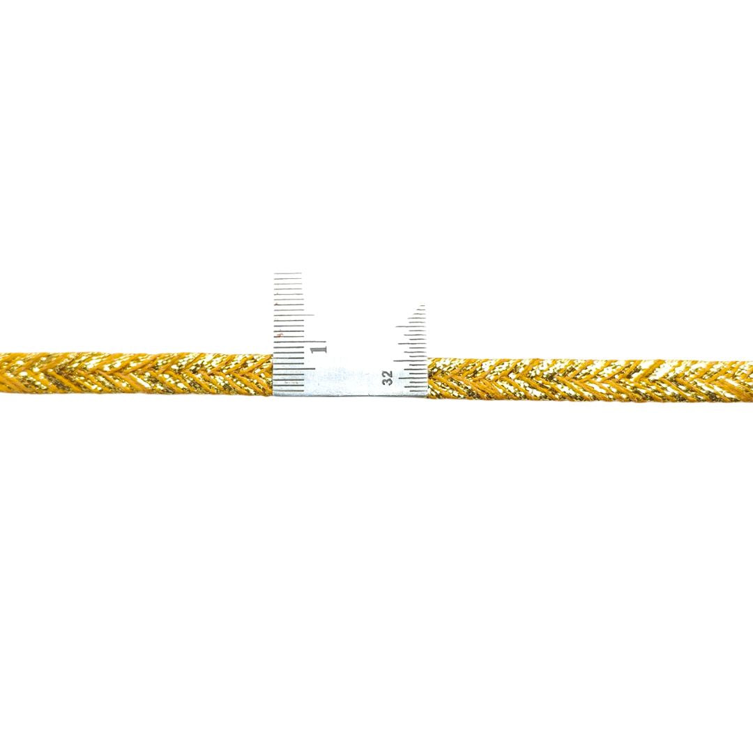 Gold braided cable with a ruler for scale on a white background
