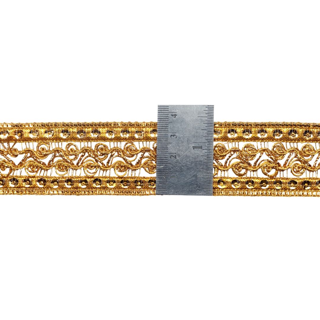 Gold lace trim with a ruler for measurement on a white background