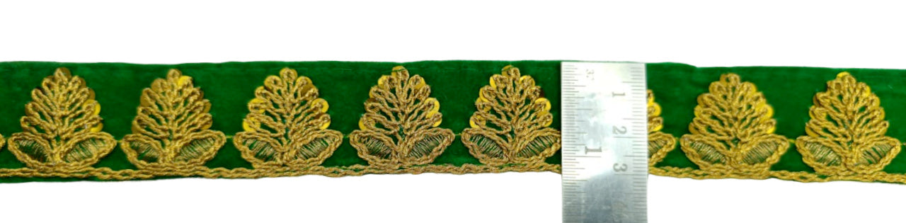 Green ribbon with gold leaf pattern and a ruler for scale