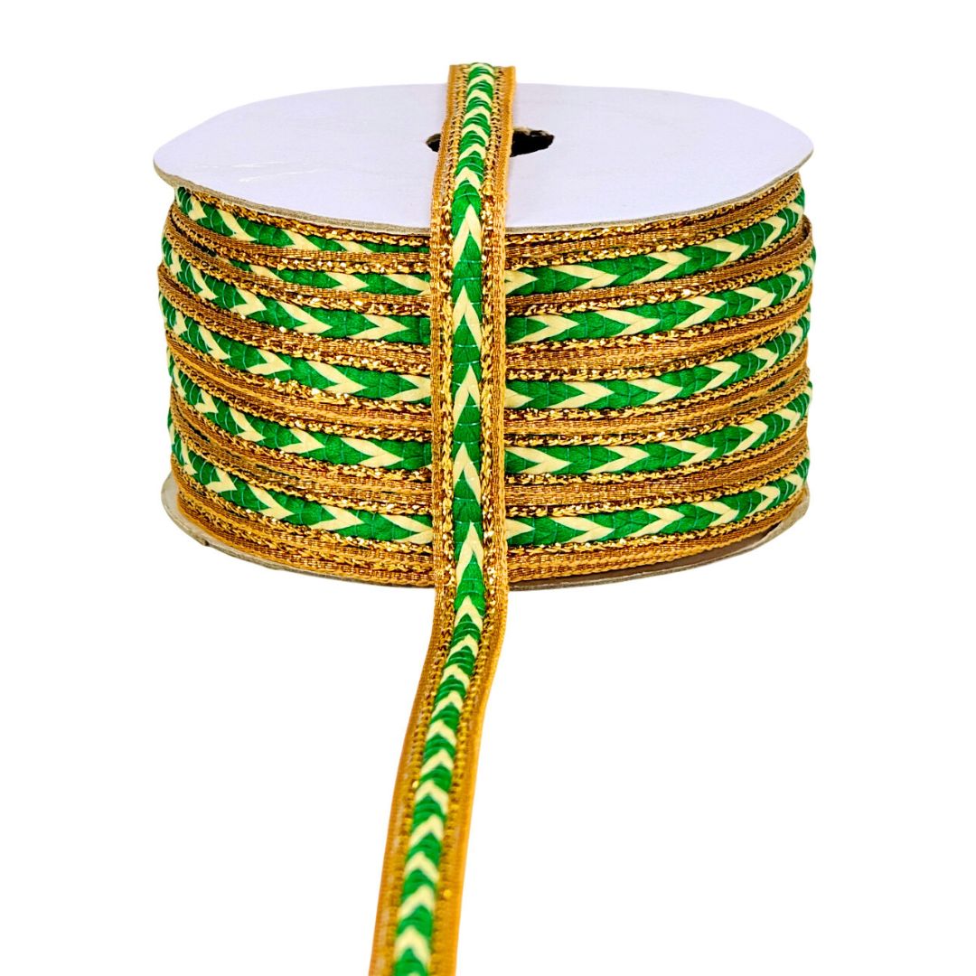Spool of green and gold ribbon on a white background
