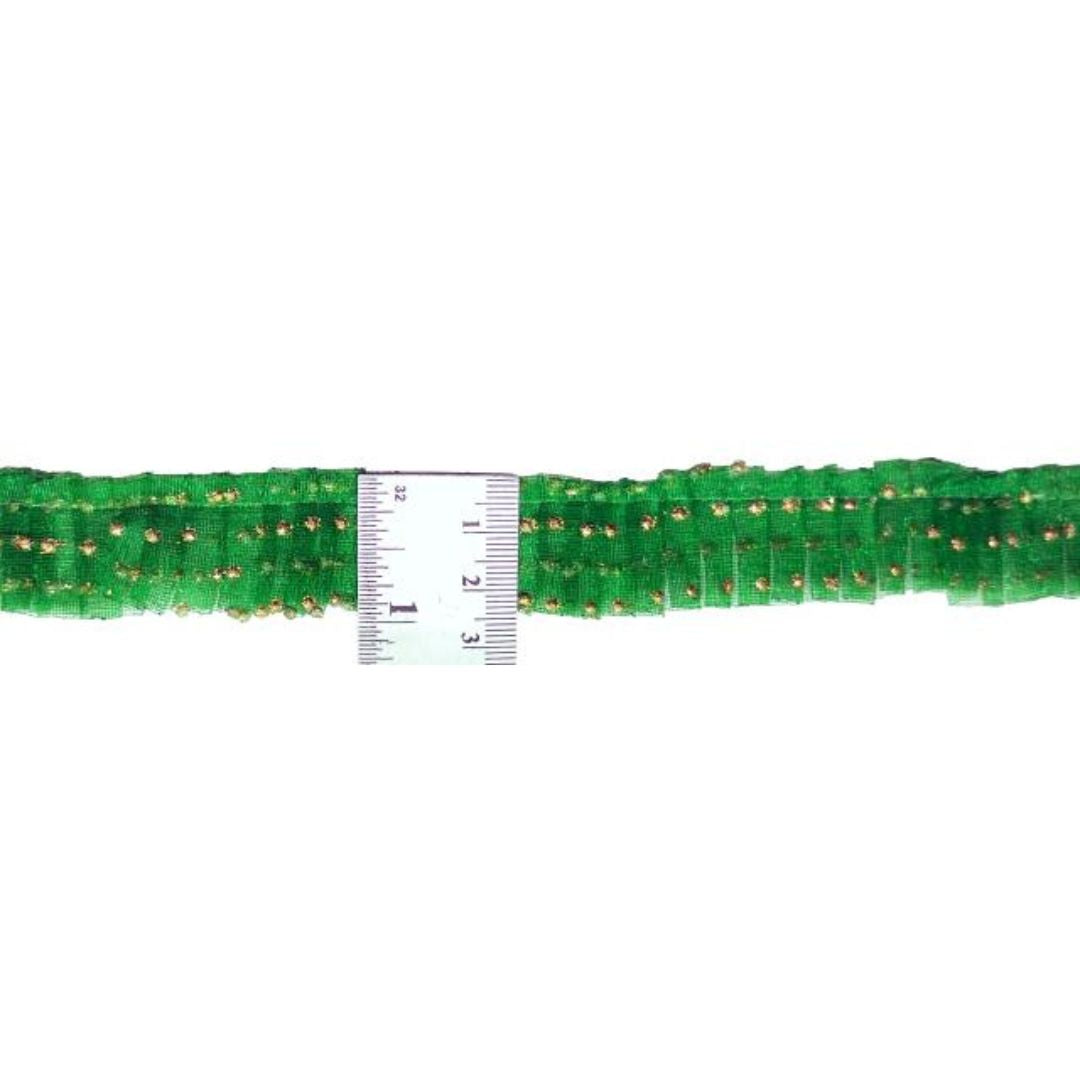 Green beaded string with a ruler for scale on a white background