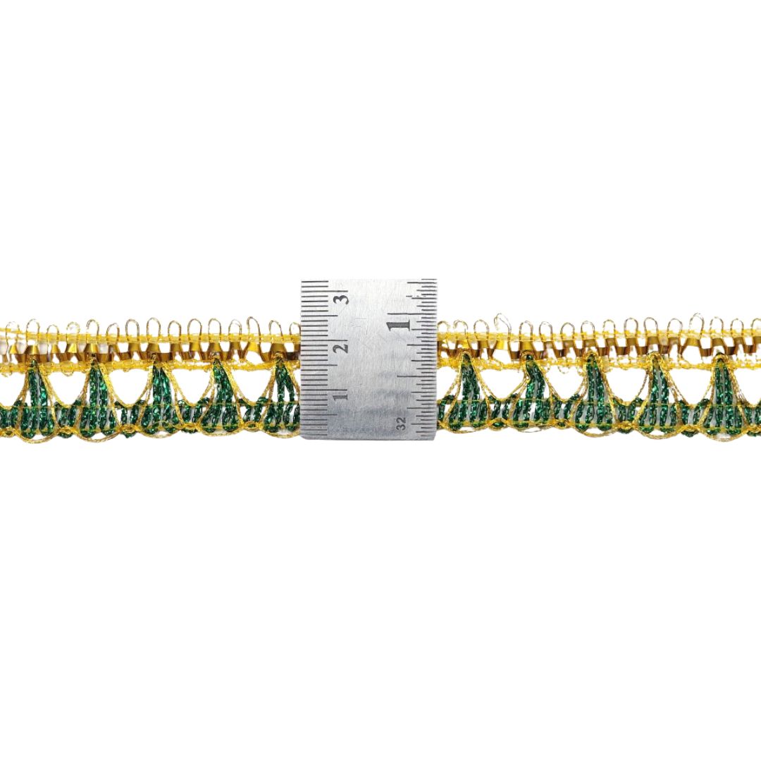 Gold and green lace fabric with a ruler for scale on a white background