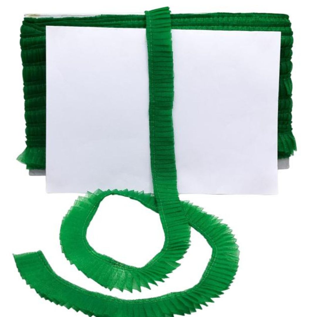 Green pleated ribbon with a white card on a white background