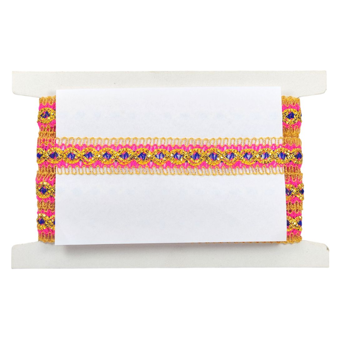 Decorative ribbon with pink and gold patterns on a white card, placed on a white surface.
