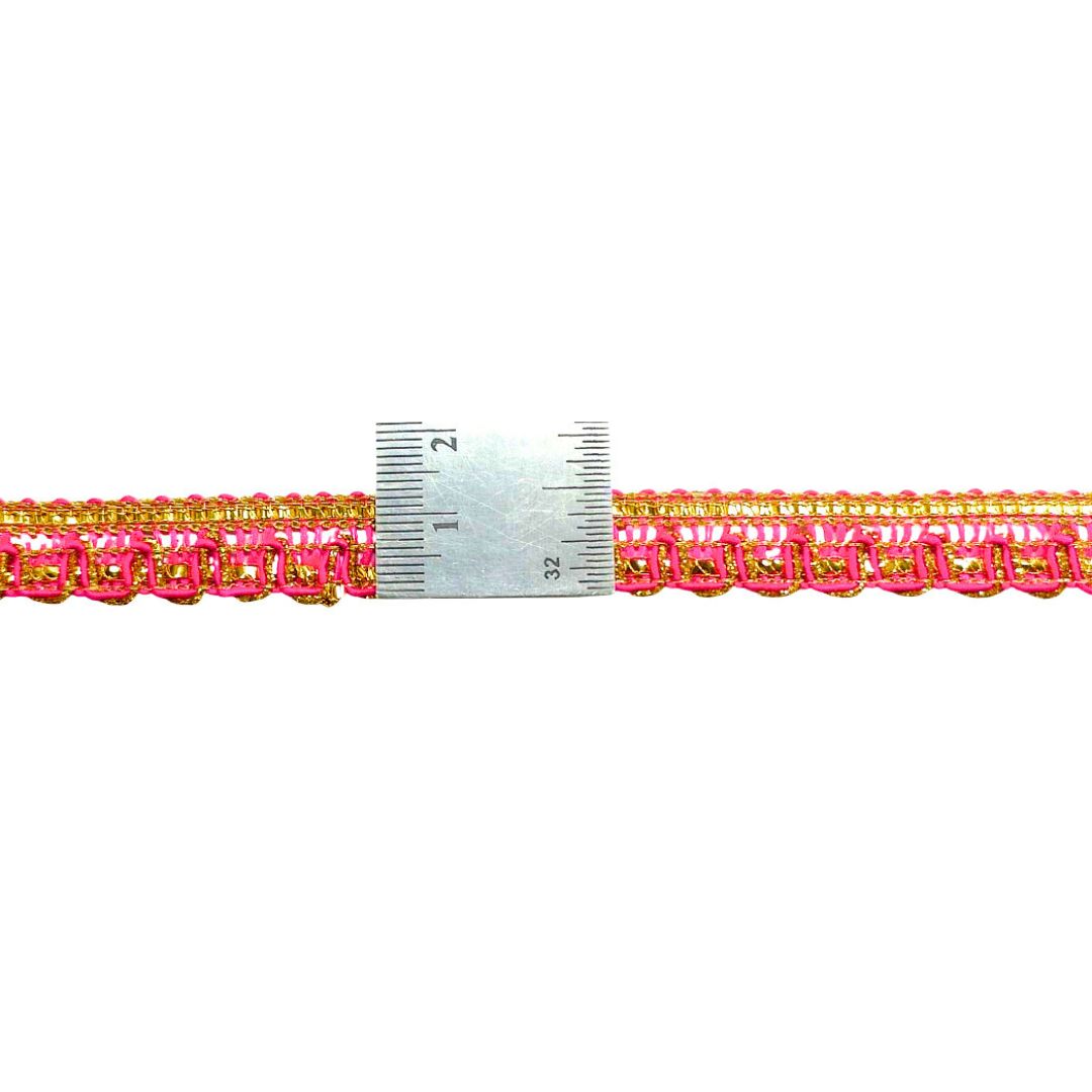 Pink and gold braided trim with a ruler for scale on a white background