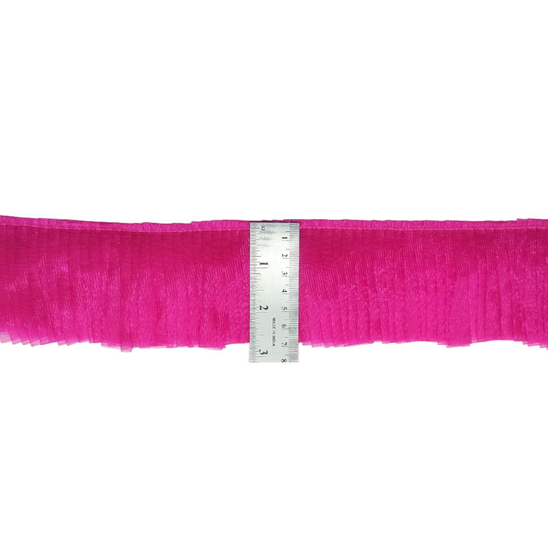 Pink fabric with a ruler for scale on a white background