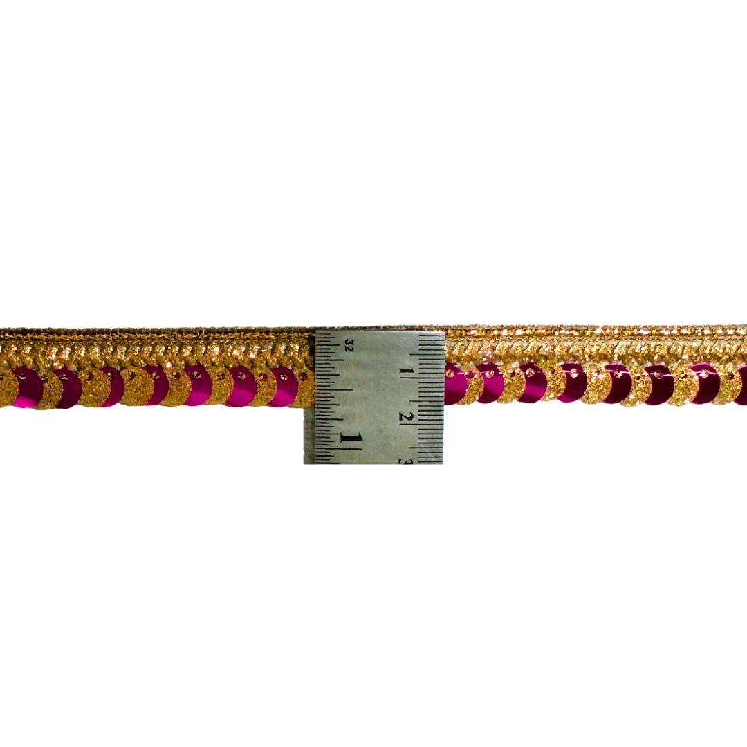Decorative trim with gold and red accents next to a ruler for measurement on a white background
