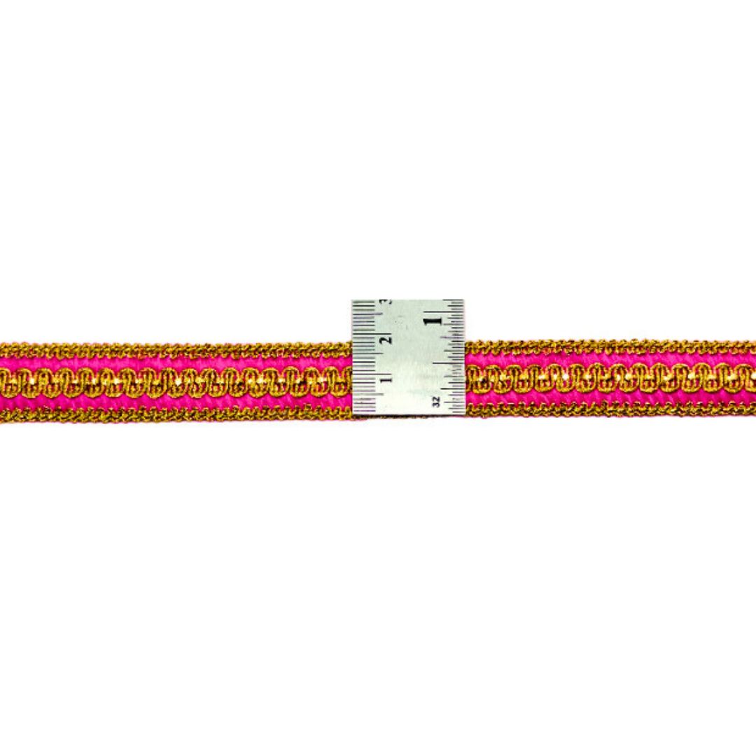 Gold and pink woven ribbon with a ruler for measurement on a white background
