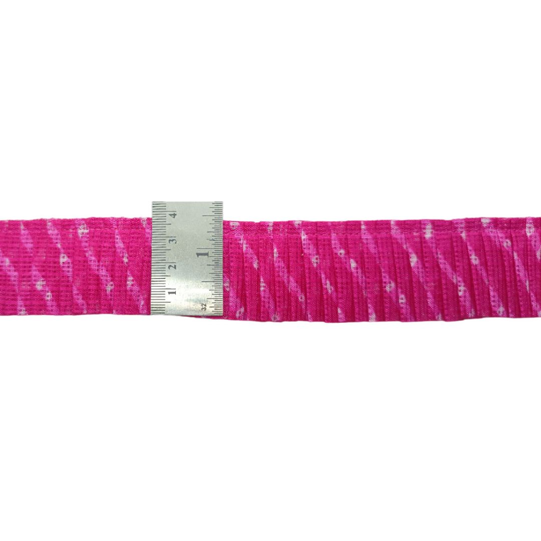 Pink and white striped ribbon with a ruler for scale on a white background