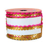 Spool of ribbon with gold and pink design on a white background