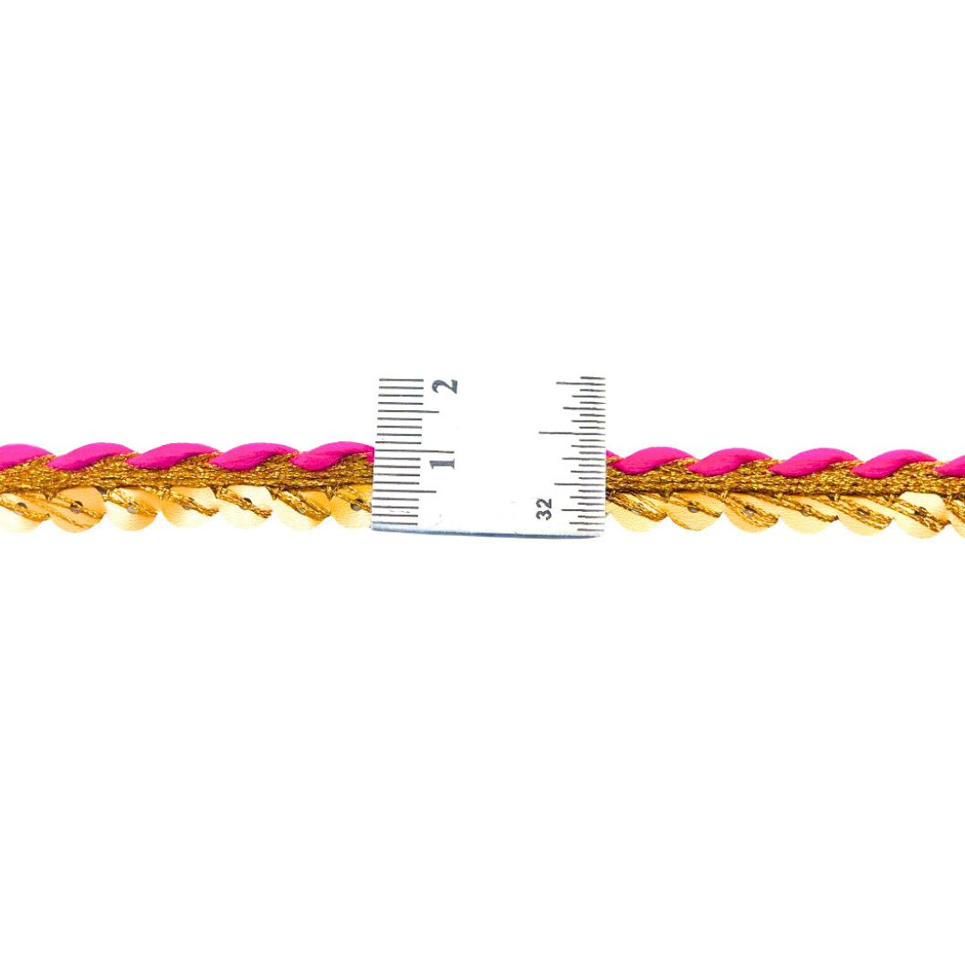 Gold and pink bracelet with a ruler for scale on a white background
