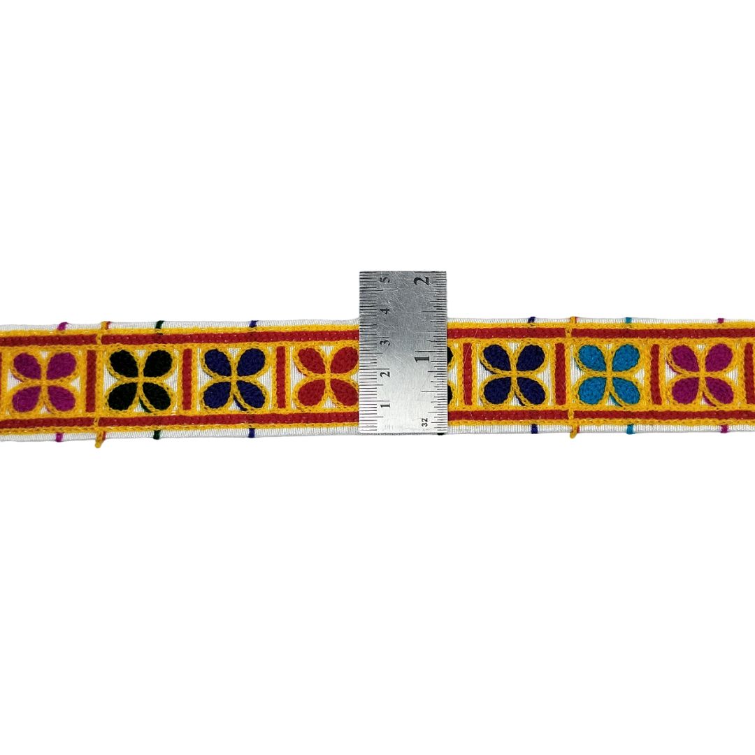 Decorative ribbon with colorful floral pattern and a ruler for scale on a white background