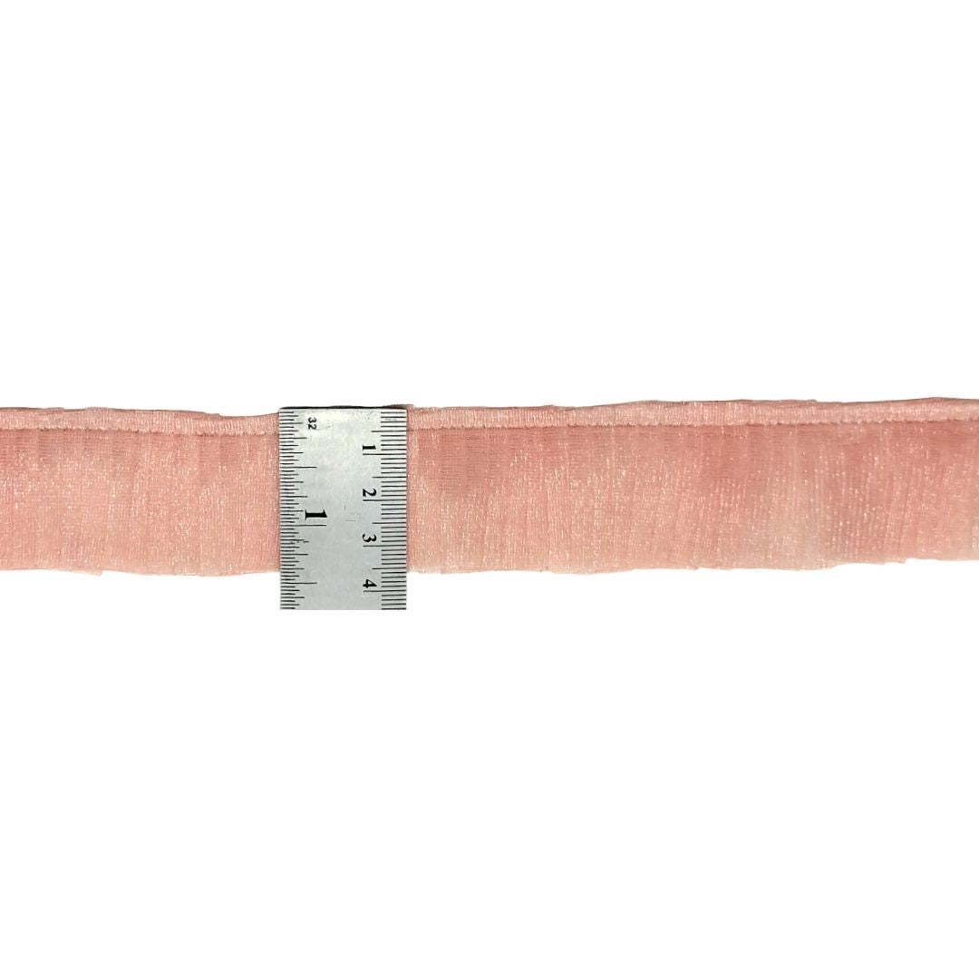 Pink ribbon with a ruler for measurement on a white background