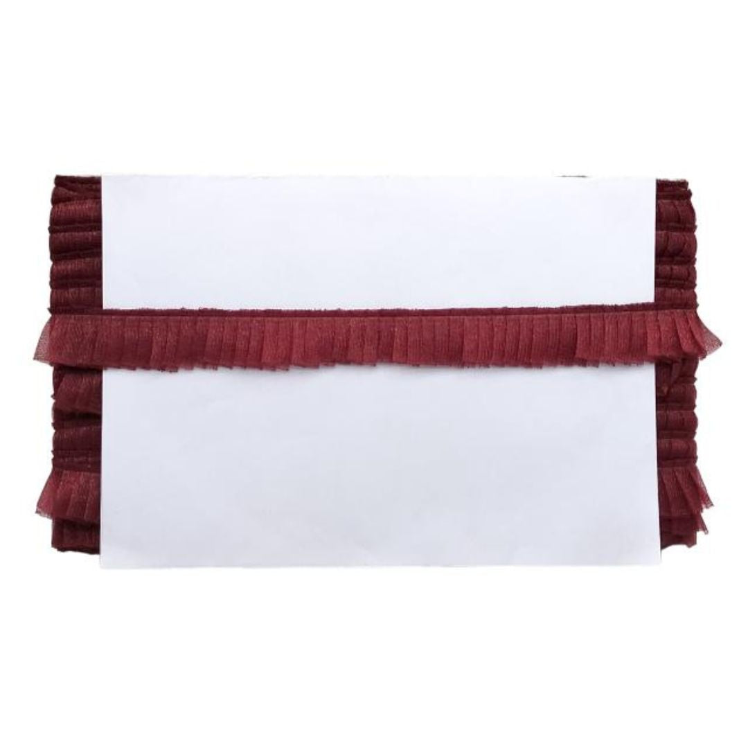 White pillow with red ruffled trim on a white background