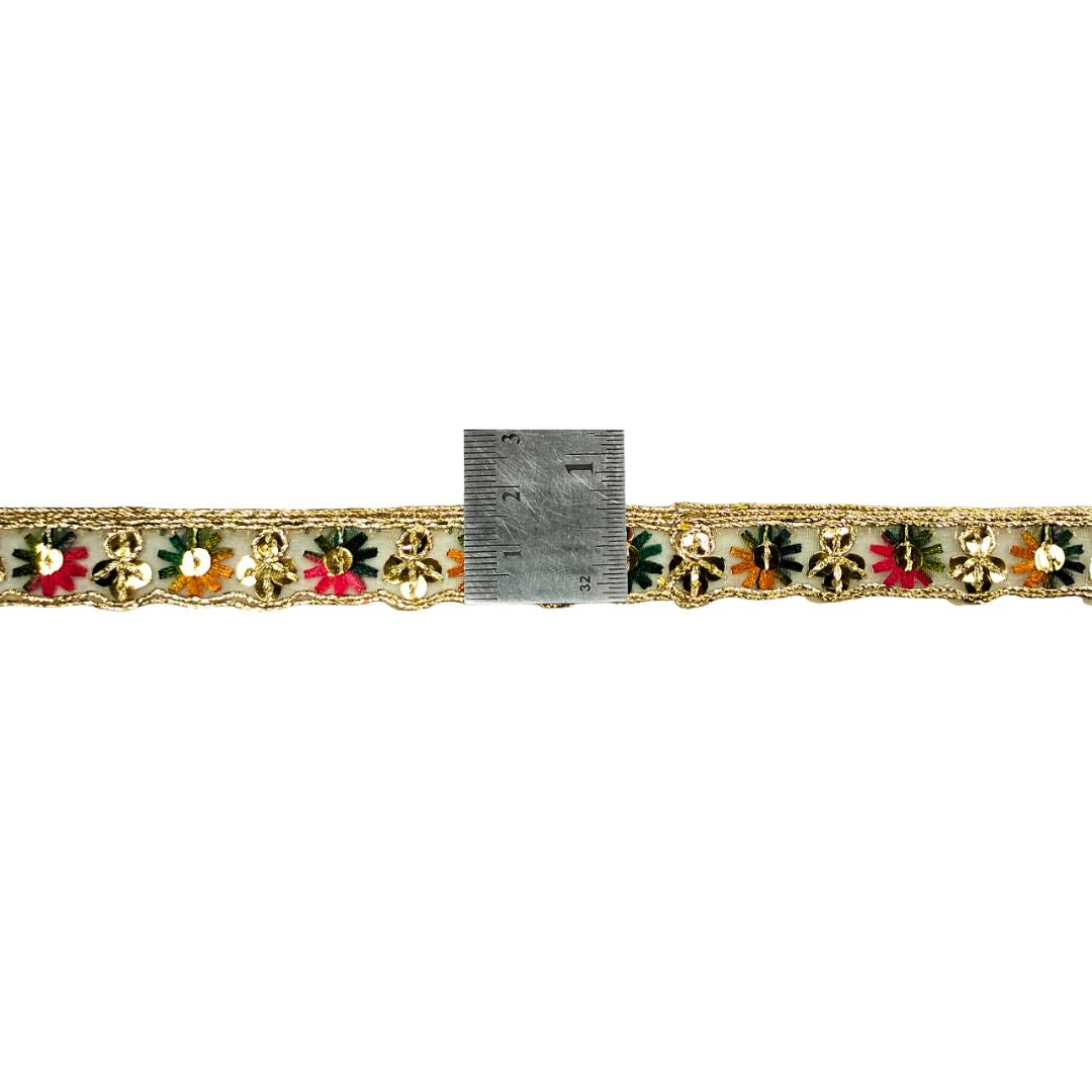 Decorative trim with floral patterns and a ruler for scale on a white background