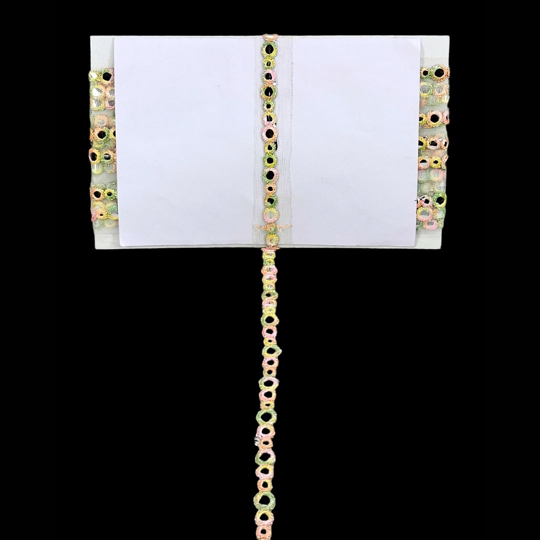 Decorative chain with multicolored beads on a white card against a black background