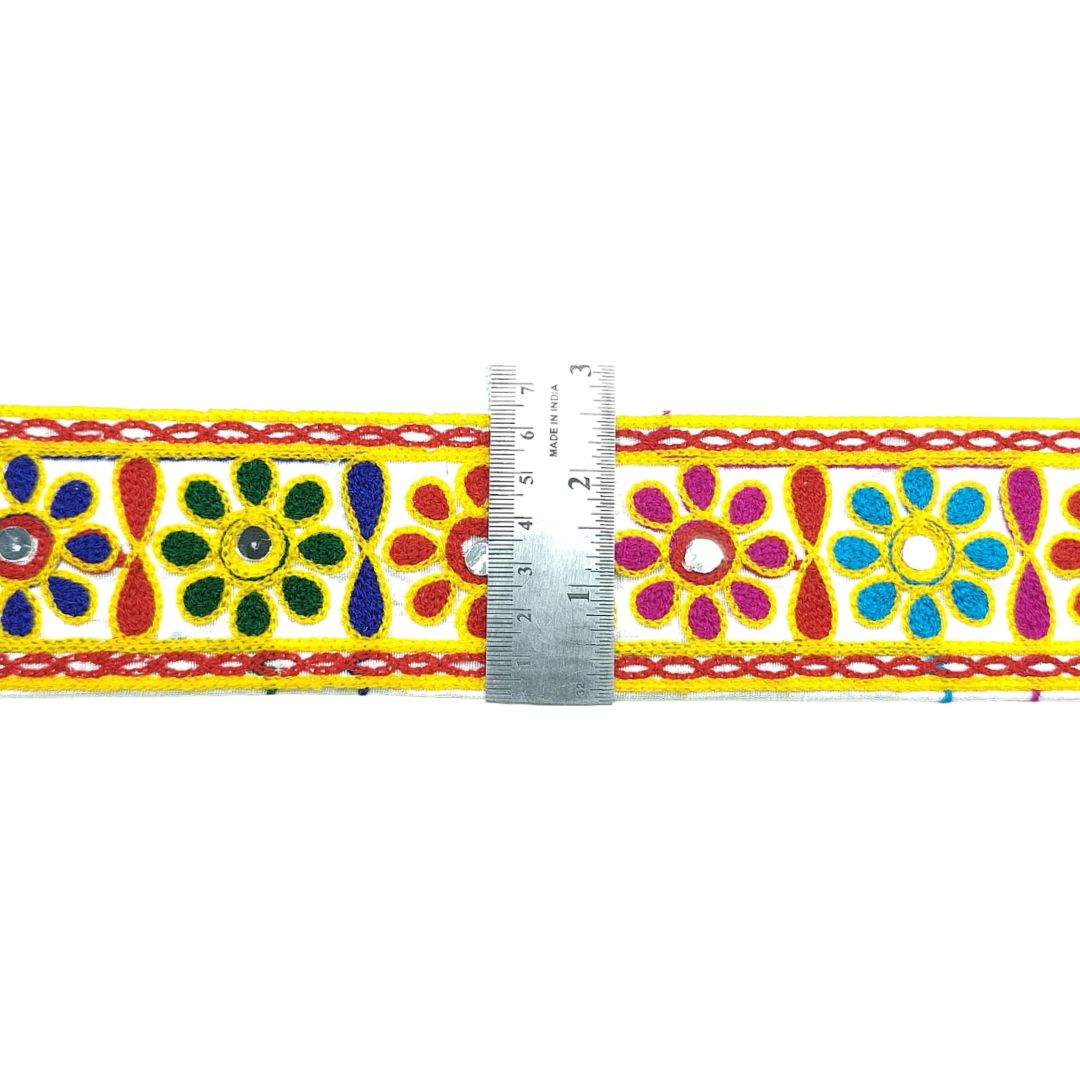Decorative ribbon with colorful floral patterns and a ruler for scale on a white background