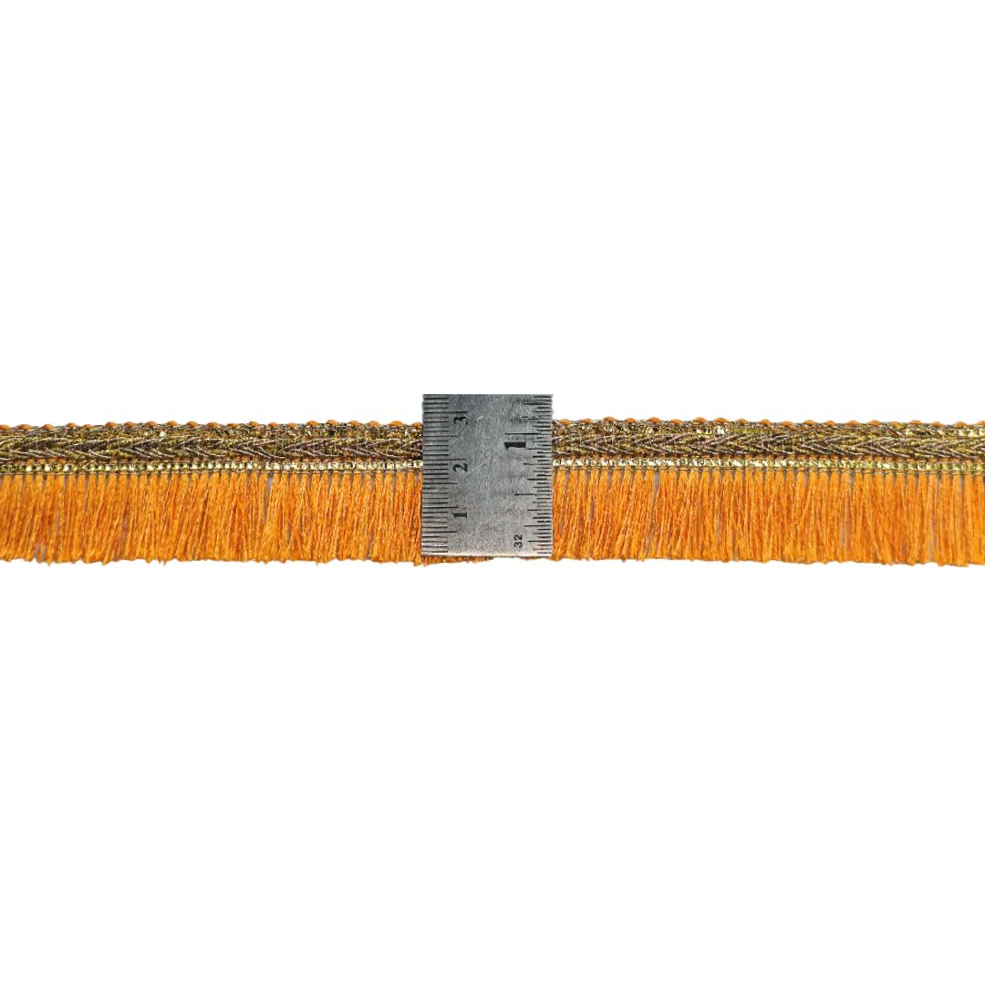 Strip of fabric with orange fringe and a ruler for scale on a white background