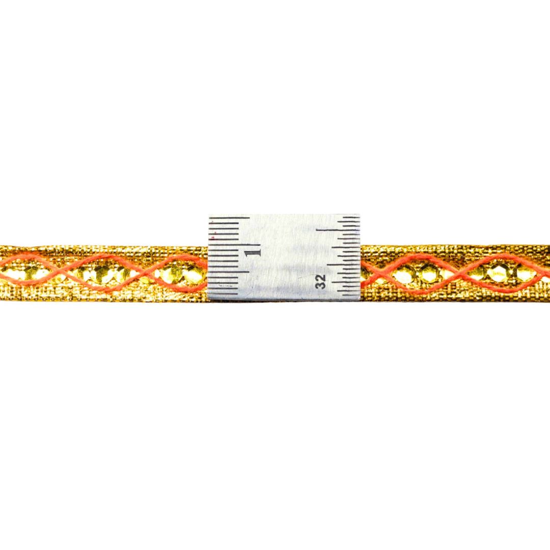 Gold and orange braided cord with a ruler for scale on a white background